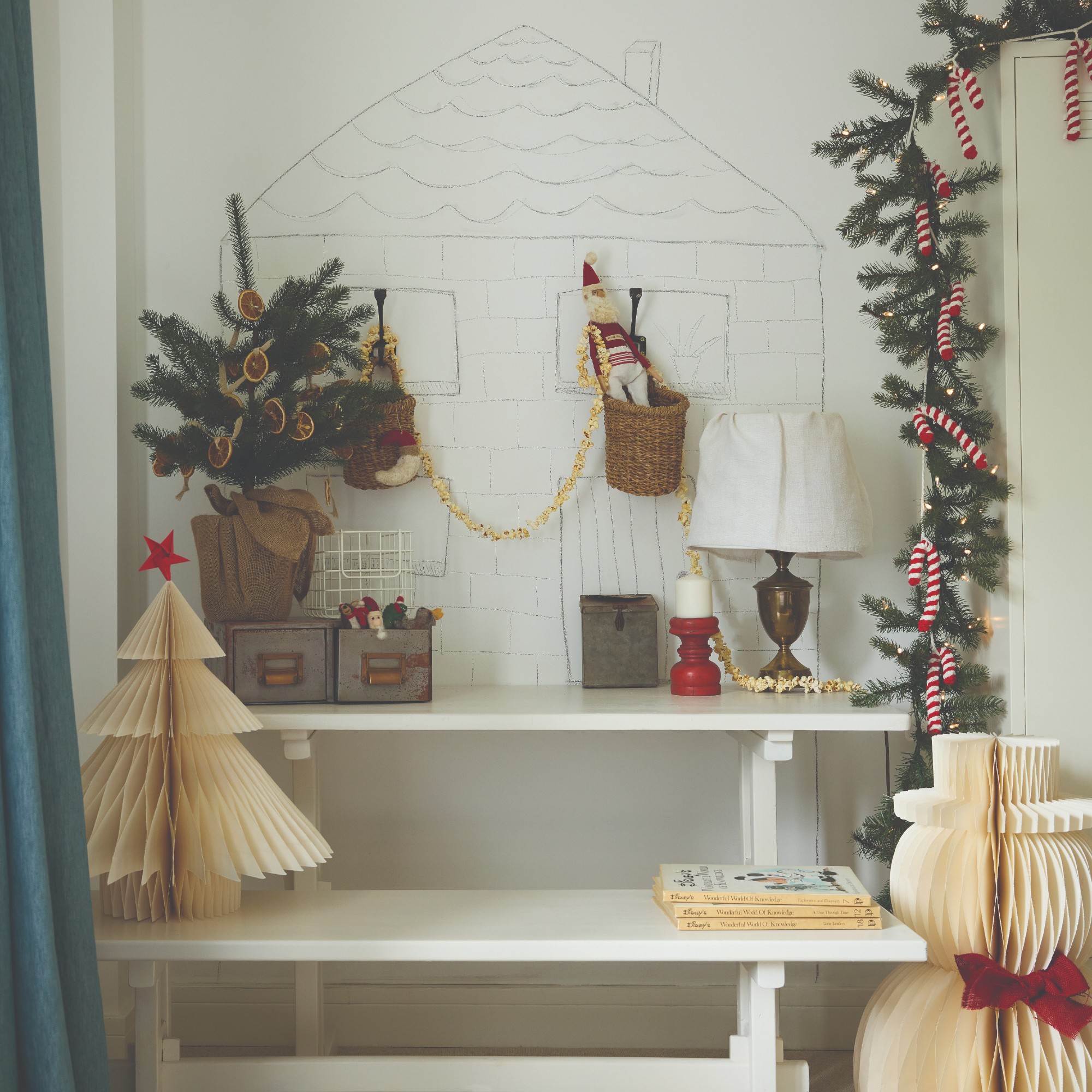 A vintage white desk and bench decorated for Christmas with a little tree decorated with dried orange slices