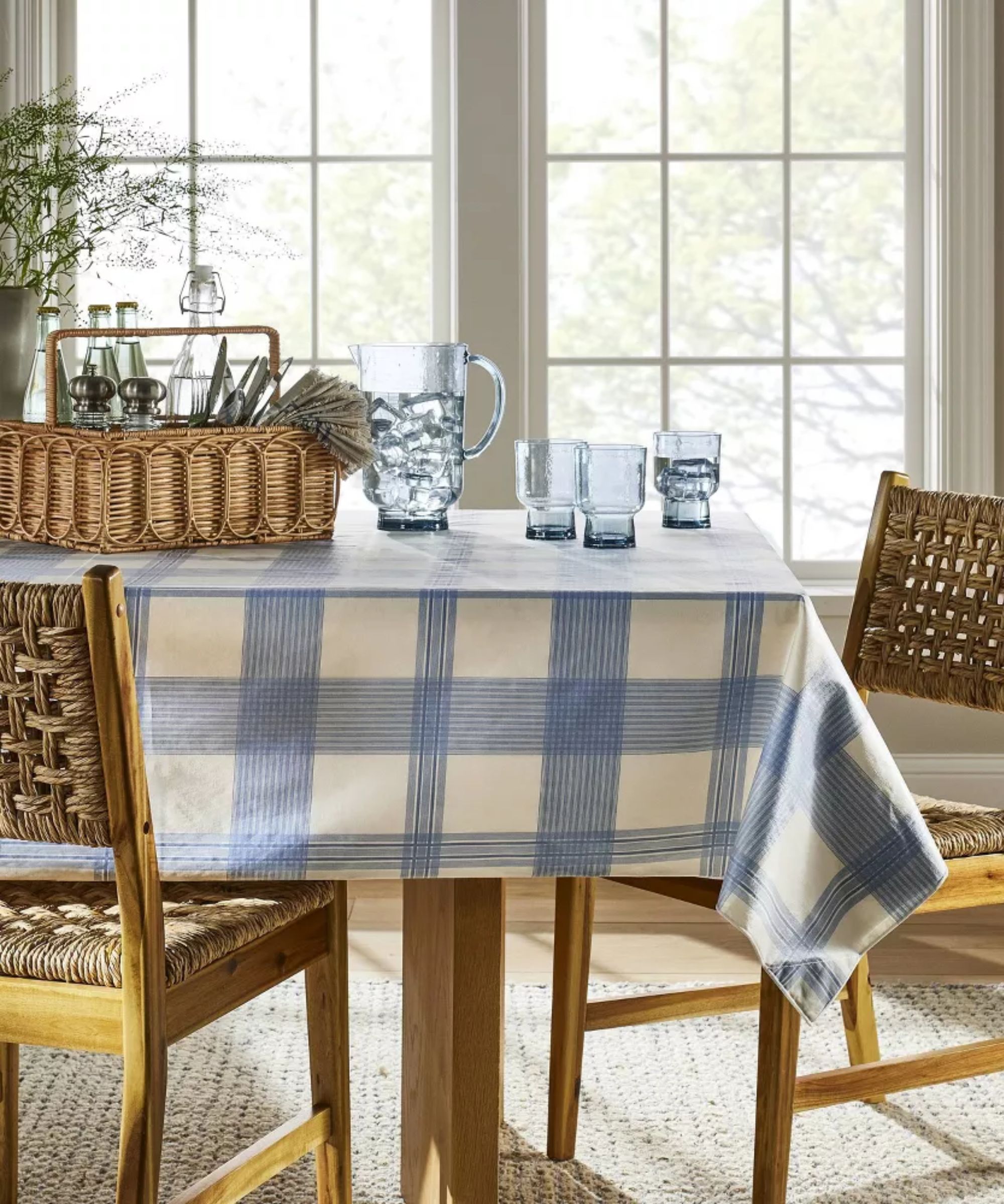 Blue and white check tablecloth with blue glassware and rattan chairs