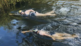 UK, Hertfordshire, River Lea, two female open water swimmers swimming in a river