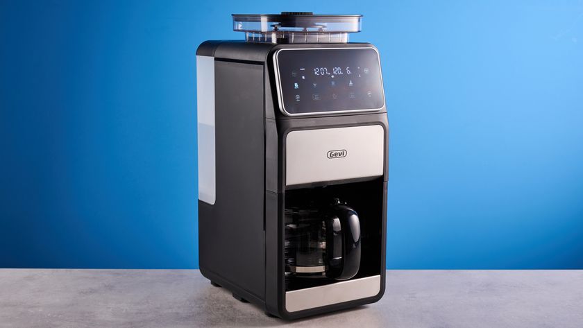 the gevi 10-cup drip coffee maker with grinder photographed against a blue background, showing the glass carafe, water tank, touch screen, and accessories including plastic filter