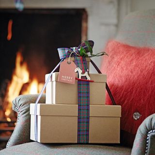 room with grey armchair having christmas gift box with ribbons