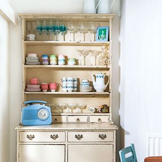 kitchen shelving with glasses and mugs and old radio