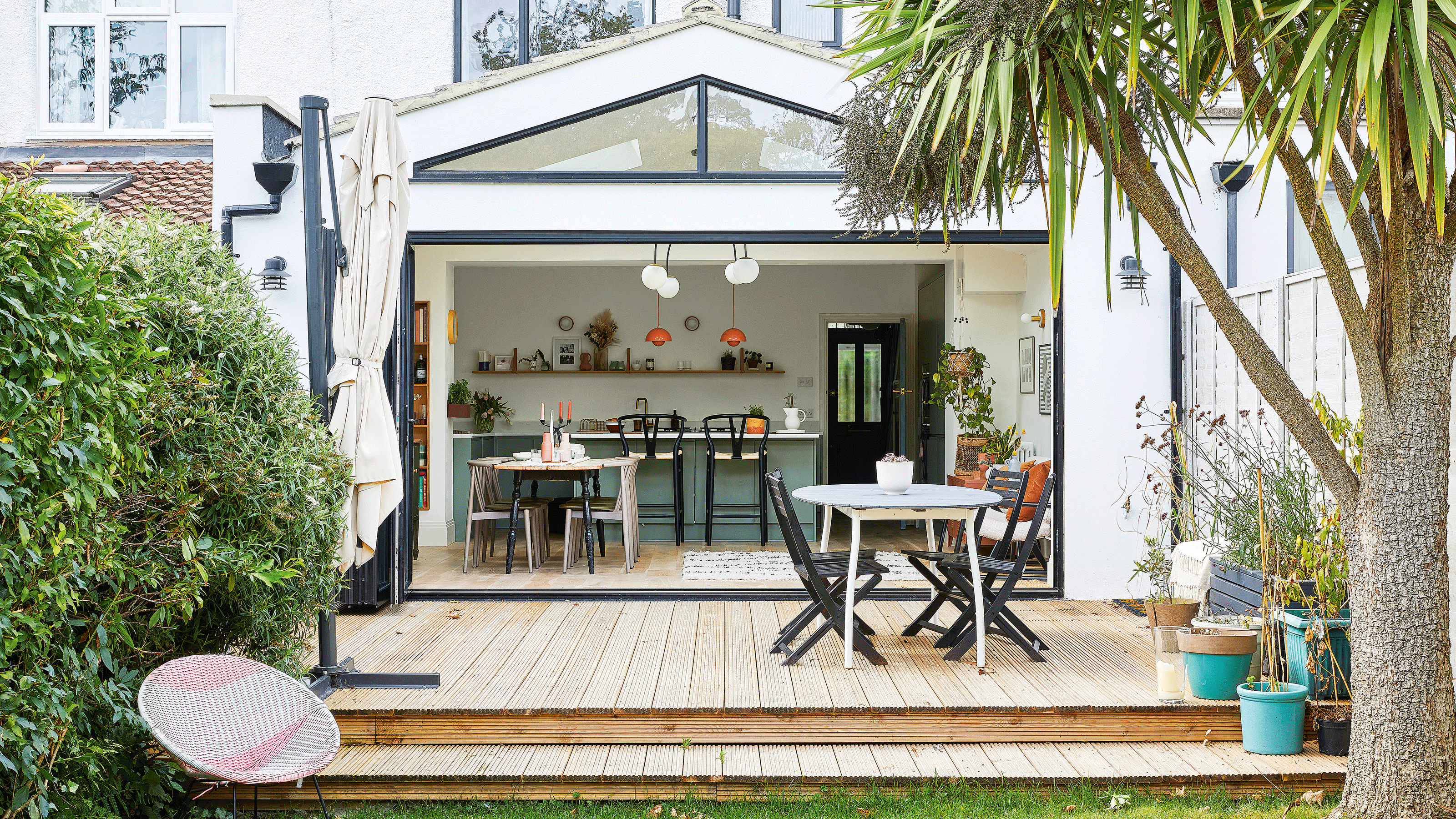 pink painted raised deck with blue painted fence and outdoor living area furniture