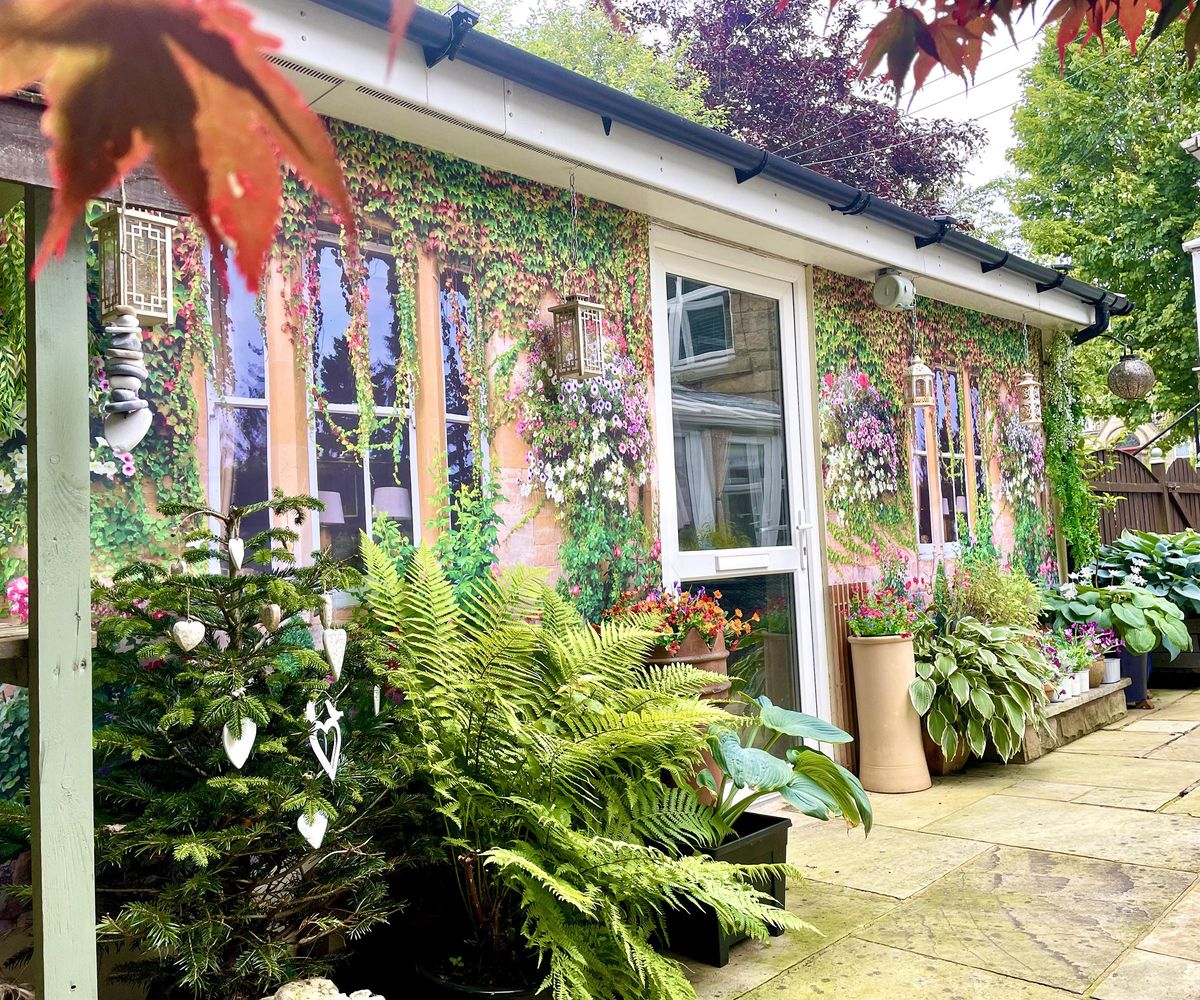 An exterior wall covered with two shower curtains with a nice window motif