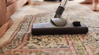 person vacuuming, the second step to take to clean a carpet