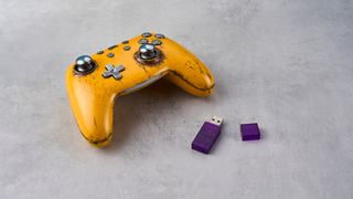 Photograph of the PB Tails Metal Crush Defender gaming controller in a metal case