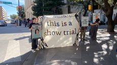 Protests stand outside the trial of a group accused of creating a distraction with fireworks and graffiti before firing upon officers with semiautomatic rifles. 