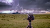 Bolt Hunter mounted on camera on tripod in landscape with bolt of lighting in the sky in distance