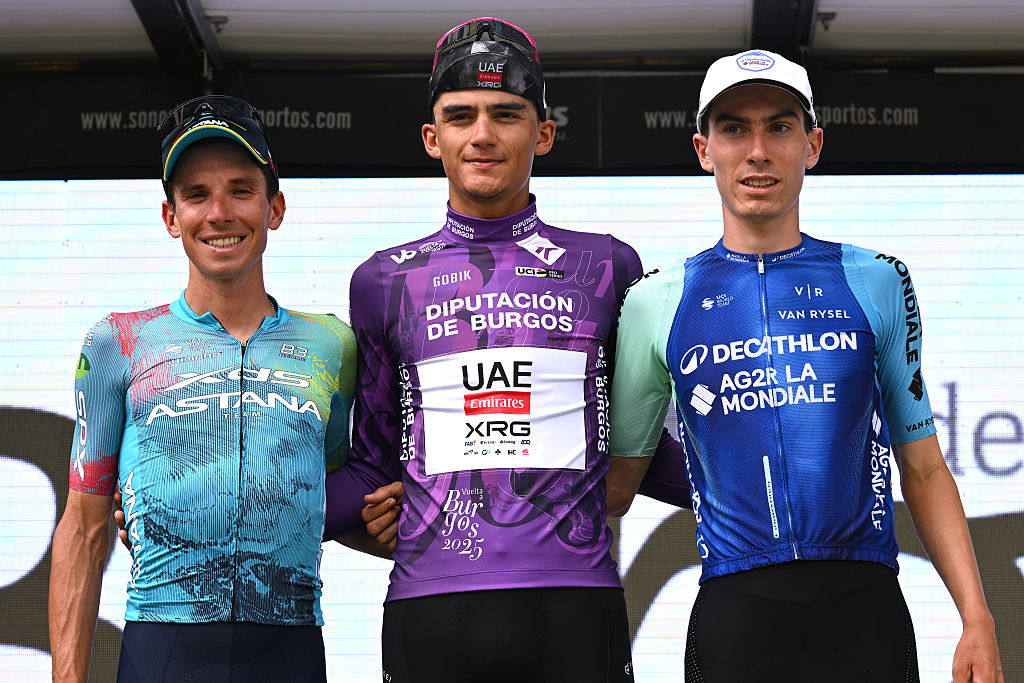 LAGUNAS DE NEILA, SPAIN - AUGUST 09: (L-R) Lorenzo Fortunato of Italy and Team XDS Astana Team on second place, overall race winner Isaac Del Toro of Mexico and UAE Team Emirates - XRG - Purple Leader Jersey and Leo Bisiaux of France and Team Decathlon AG2R La Mondiale Team on third place pose on the podium ceremony after the 47th Vuelta a Burgos 2025, Stage 5 a 138.3km stage from Quintana del Pidio to Lagunas de Neila 1866m on August 09, 2025 in Lagunas de Neila, Spain. (Photo by Antonio Baixauli/Getty Images)