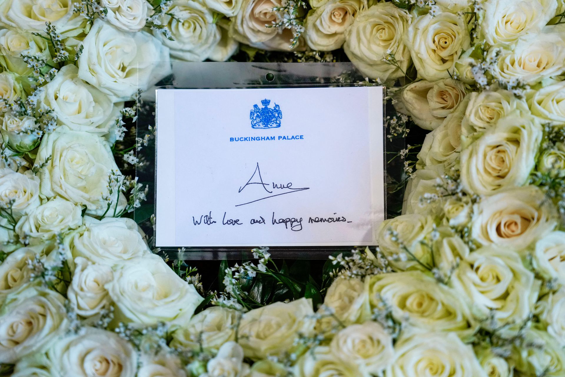 A wreath of white roses with a note that says
