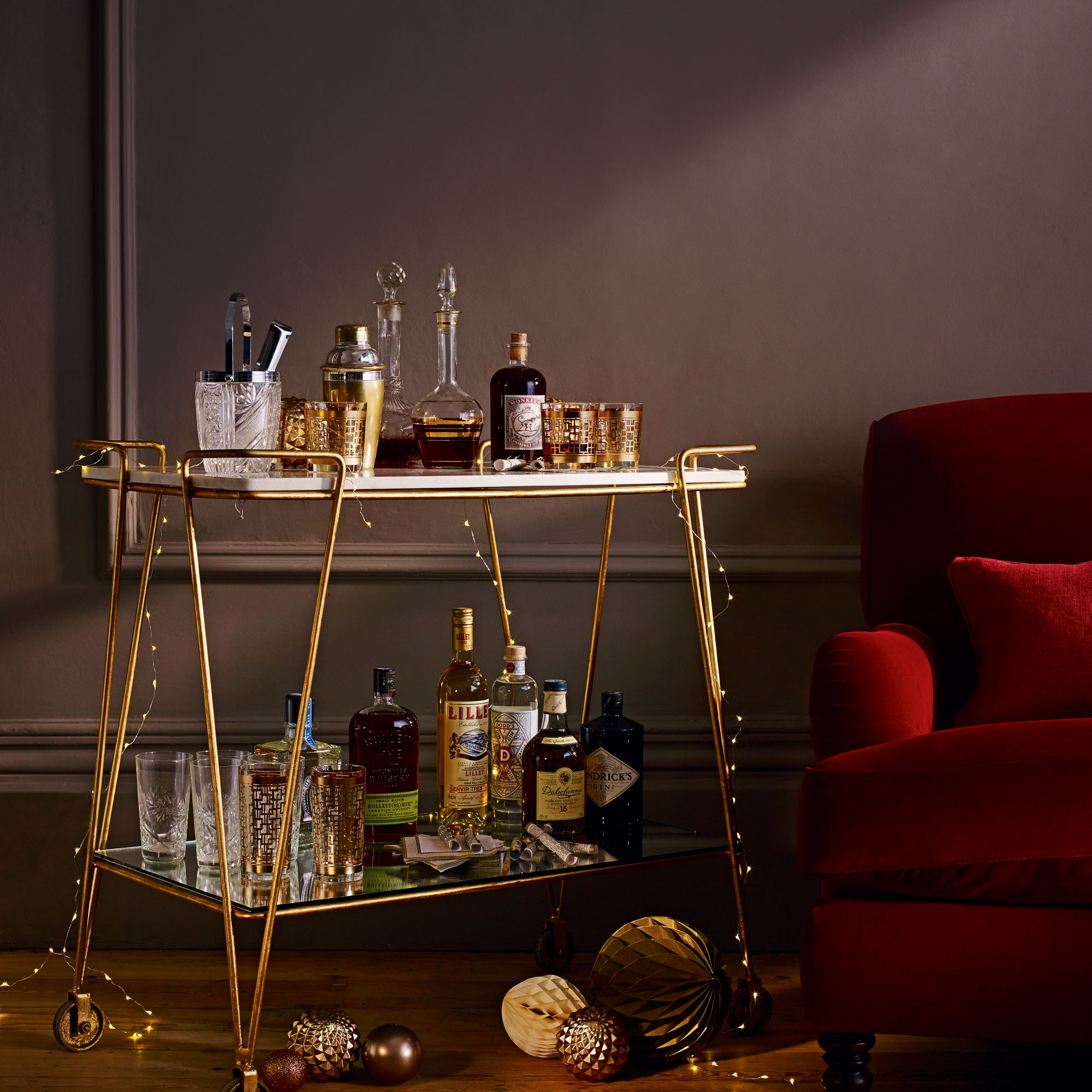 Gold bar cart in a living room with a red sofa