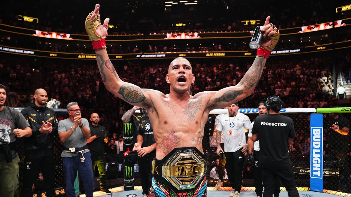 Alex Pereira celebrates with hands aloft after his TKO victory in the light heavyweight championship fight at UFC 307.