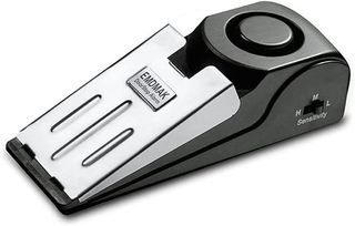 A black wedge-shaped door stop alarm with a silver sensor