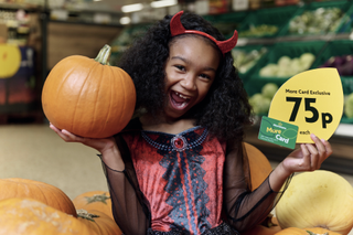 Girl with devil horns holding pumpkin at Morrisons