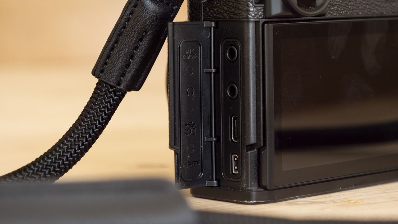 All-black Fujifilm GFX100RF rangefinder-style camera on a wooden table