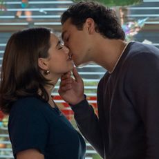 Ella Bright as Hannah Wells and Belmont Cameli as Garrett Graham kissing in a diner with snowflake stickers on the windows