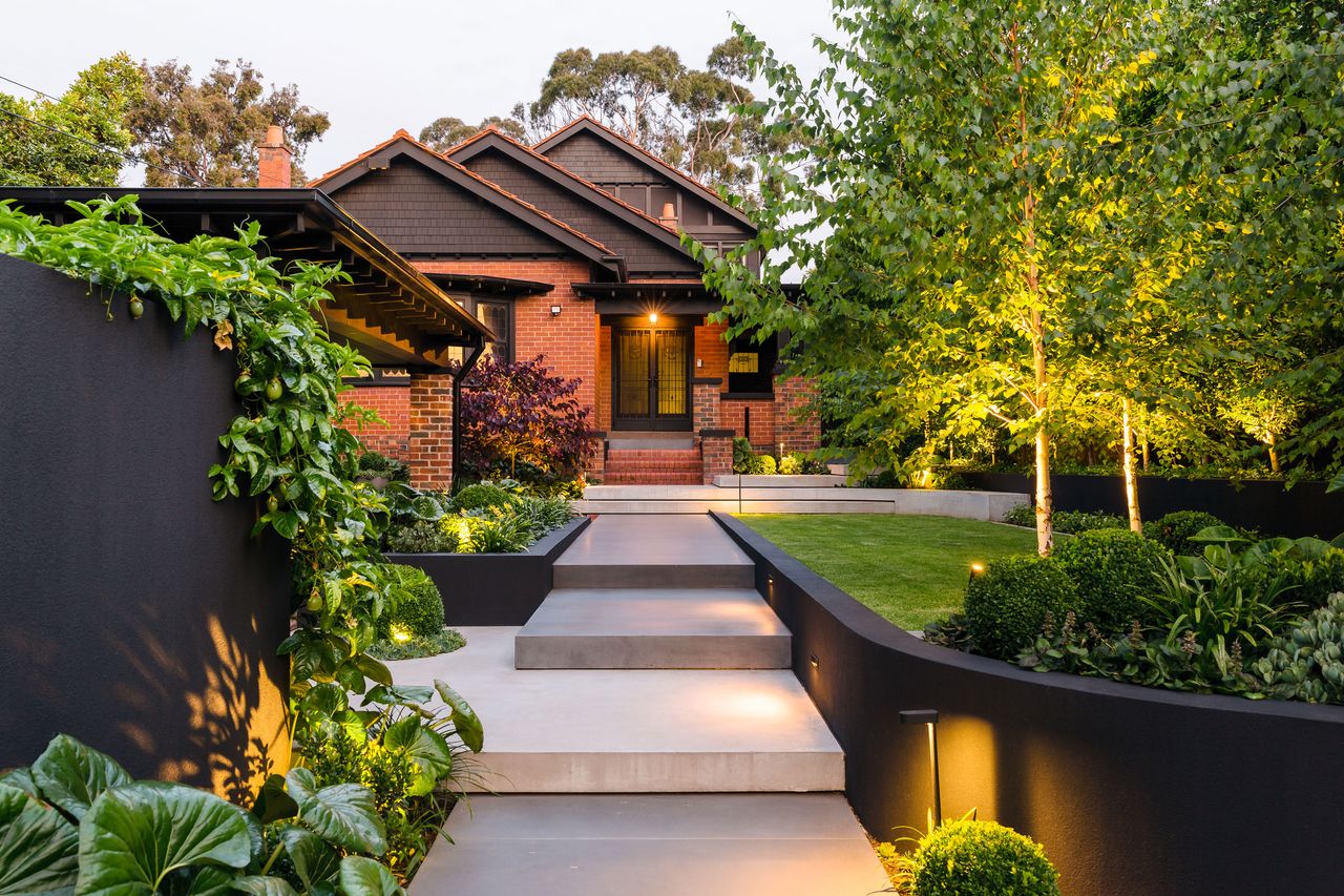 a front yard with a layered lighting scheme