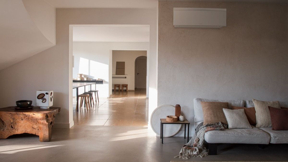 A Daikin Emura air to air heat pump unit on the wall of a beige room