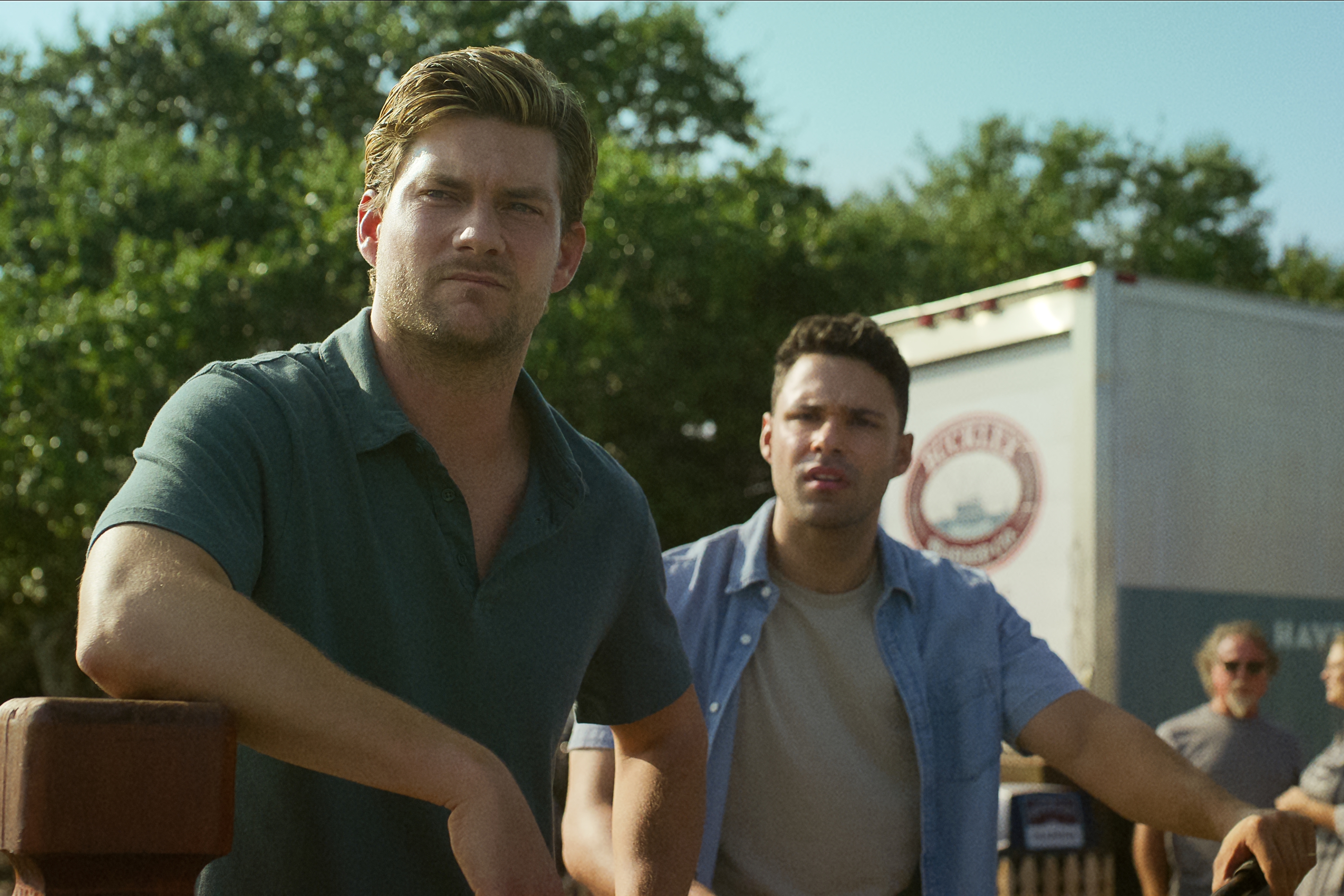 Jake Weary as Cane Buckley, Rafael Silva as Shawn West looking off into the distance while at work at the fishing company in the waterfront