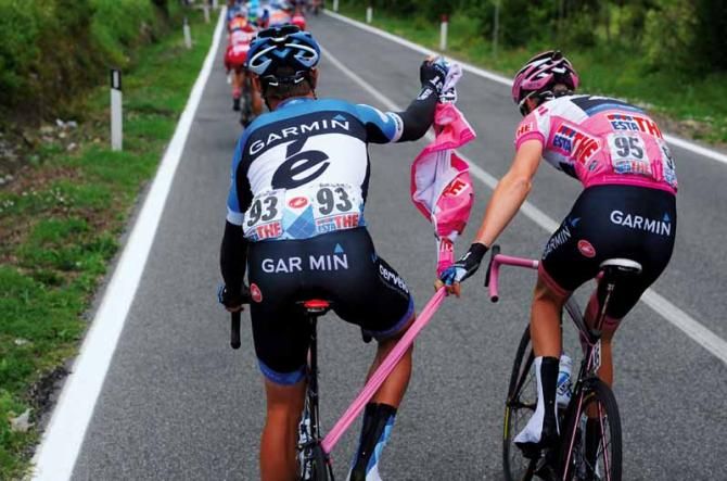 Taking a tow: Giro leader Ryder Hesjedal and teammate Jack Bauer have a problem when the Canadian's arm warmers are caught up in Bauer's bike