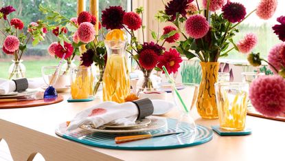 A tablescape set with vases and colorful serveware