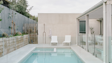 very light and clean pool area with grey wooden fences around it 