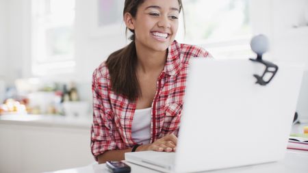 Woman in front of her laptop, talking on the best webcam