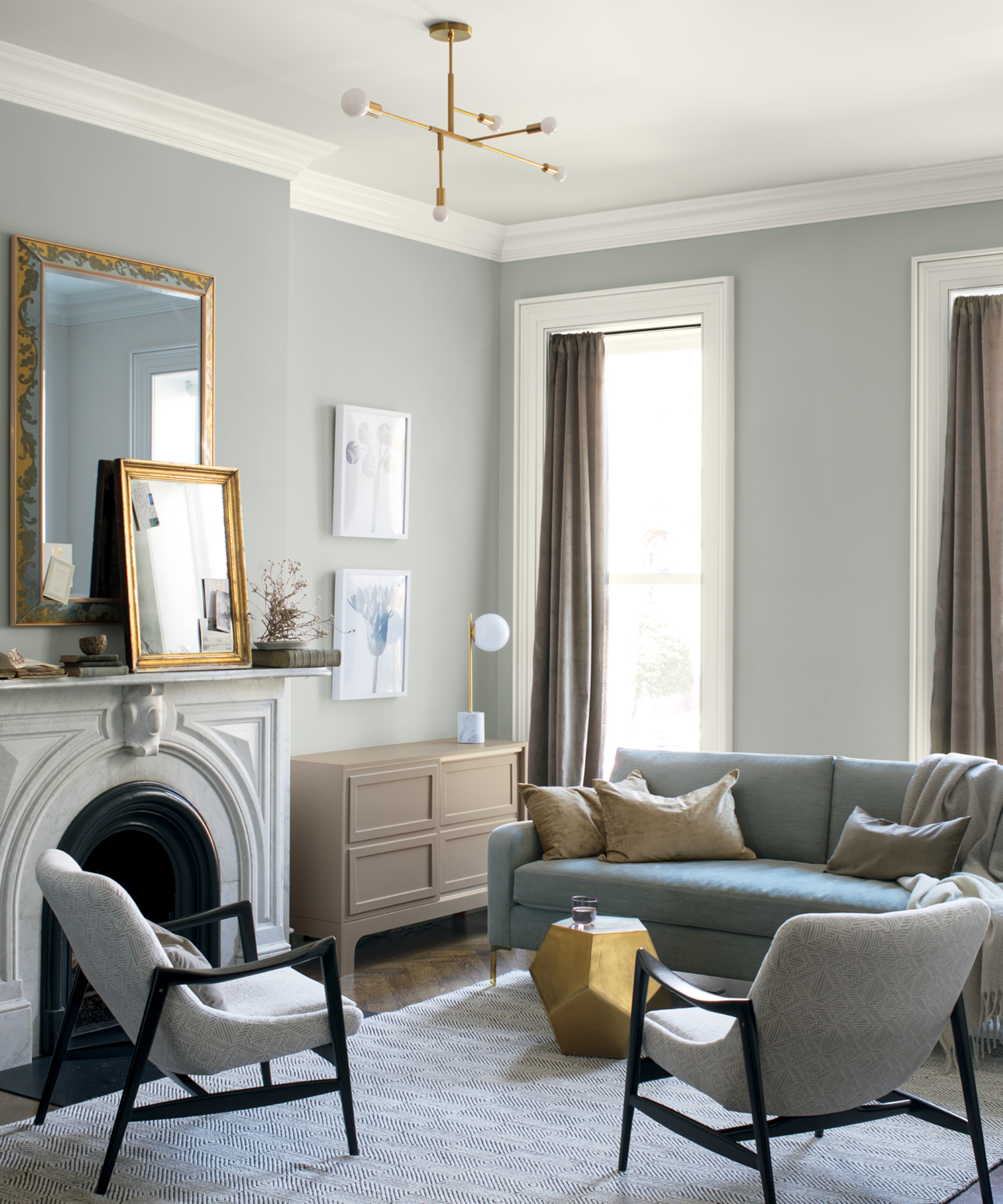 A grey living room by Benjamin Moore with two mirror over fireplace mantel