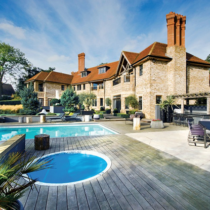 exterior of mansion with swimming pool and beach chair