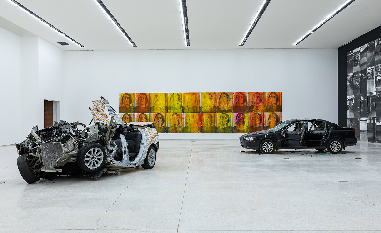 Crashed cars and pop art canvases on back wall