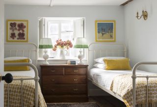 Twin beds white metal bedframe, yellow cushions