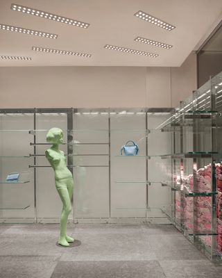Mannequin in Acne Studios store against chrome rails
