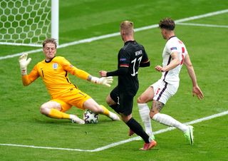 Jordan Pickford, left, saves from Germany’s Timo Werner, centre