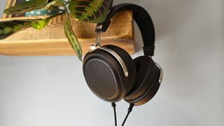 The Fiio FT1 Pro headphones hanging off a wooden shelf.