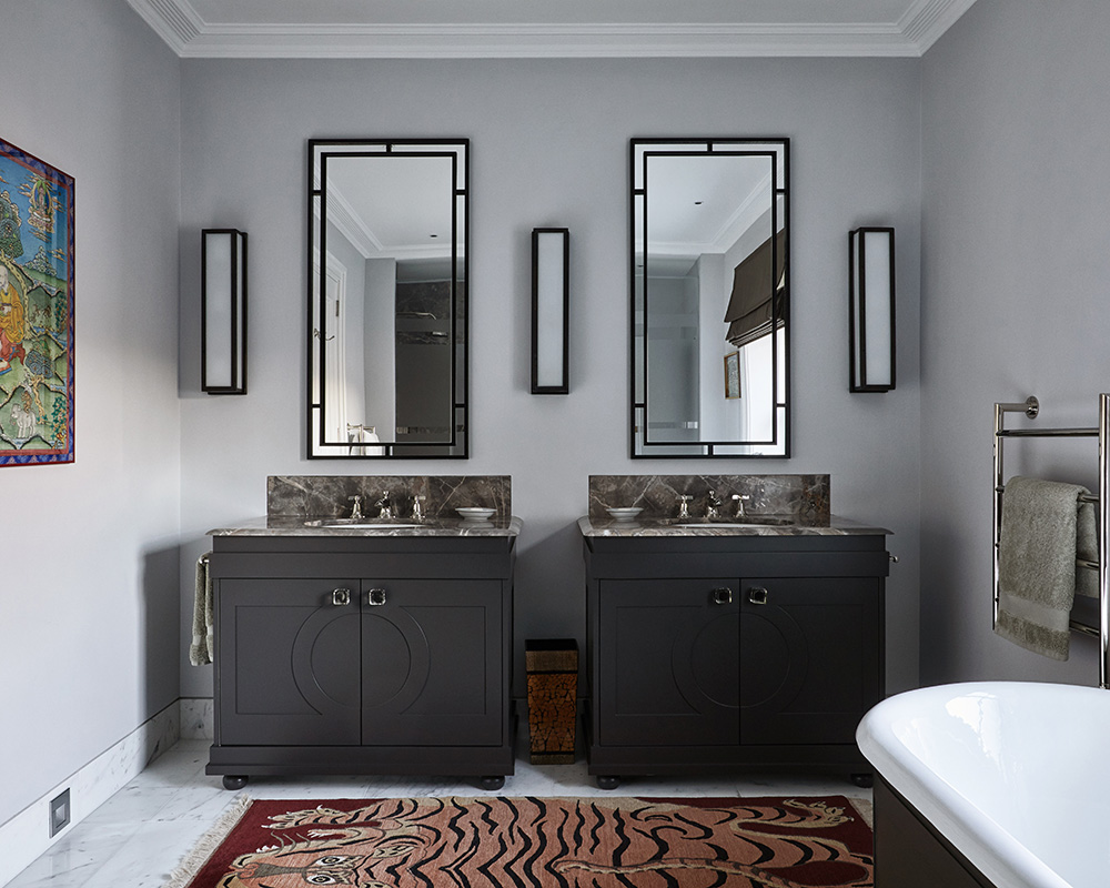 An example of bathroom paint ideas showing a bathroom with two dark green vanity units and a tiger rug on the floor