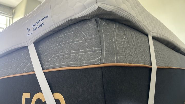 The corner straps of the Helix Premium Memory Foam Mattress Topper placed on a mattress.