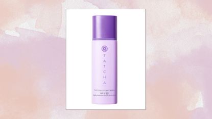 A close-up of the Tatcha The Silk Sunscreen SPF 50/ in a beige and purple watercolour paint-style template