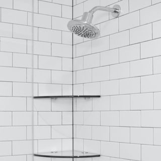 a shower head with white subway tiles