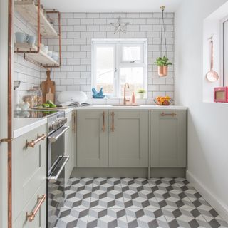 white and grey kitchen with grey graphic floor tiles, white metro tiles on walls, copper pipe shelving and handles, copper tap