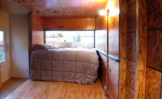 The finished house contains four separate sleeping areas (one of which can also be used as a living room), each formed from a 7 x 7 x 7.5 foot space, which just happens to be New York State's minimum requirements for bedroom size