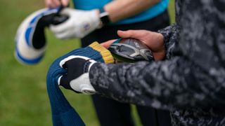 A golfer putting a headcover on his golf club after hitting a shot