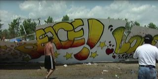Woodstock attendees tear down a wall in the Woodstock '99: Peace, Love, and Rage trailer