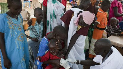 Staff from Medecins Sans Frontieres vaccinate children in South Sudan