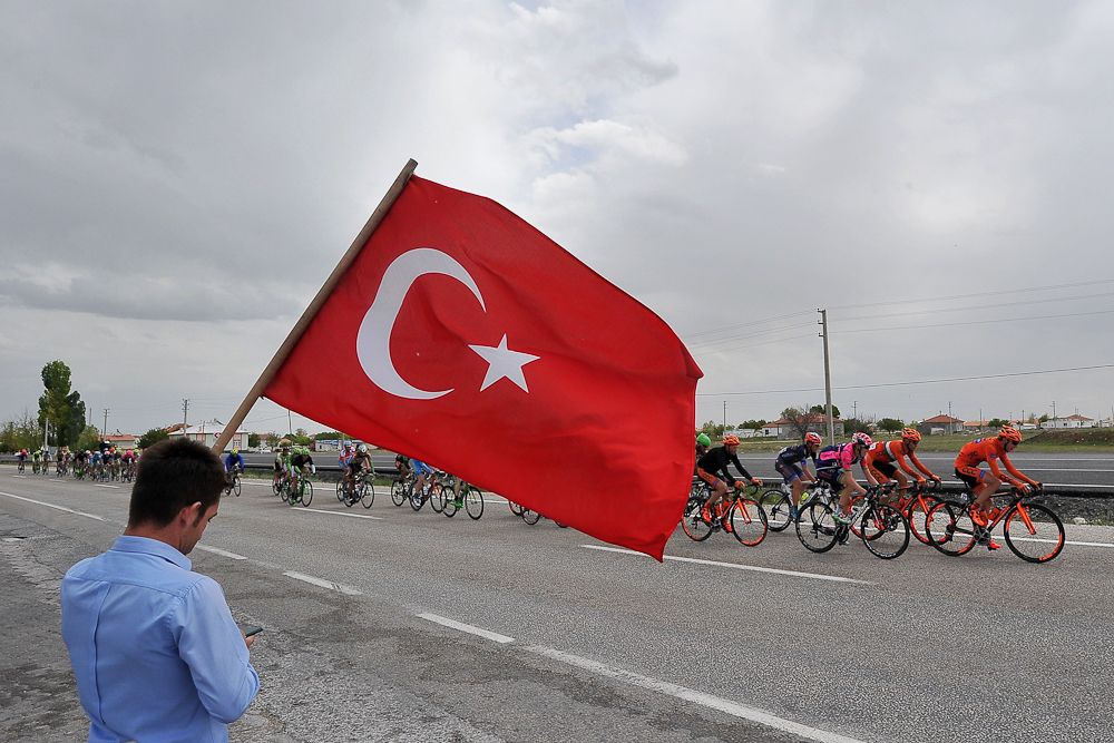 A spectator with a Turkish flag as the peloton passes