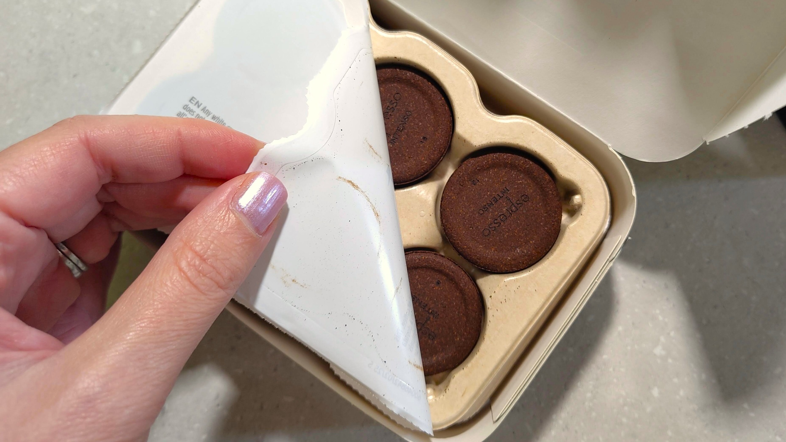 Person opening packet of Lavazza Tabli coffee machine tabs