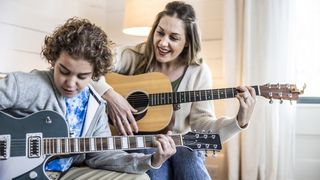 Boy and mom playing guitar