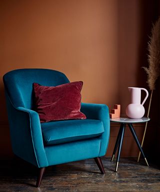 blue velvet armchair and terracotta wall
