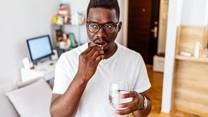 man taking a fish oil supplement