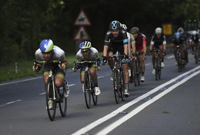Simon Yates being led out by his Orica teammate in front of Team Sky's Luke Rowe