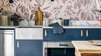 kitchen with leaf mural, white ceramic sink and blue cabinetry